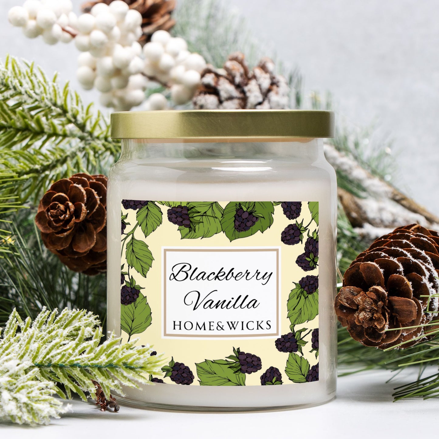 Candle jar with 'Blackberry Vanilla' label surrounded by pine cones and branches