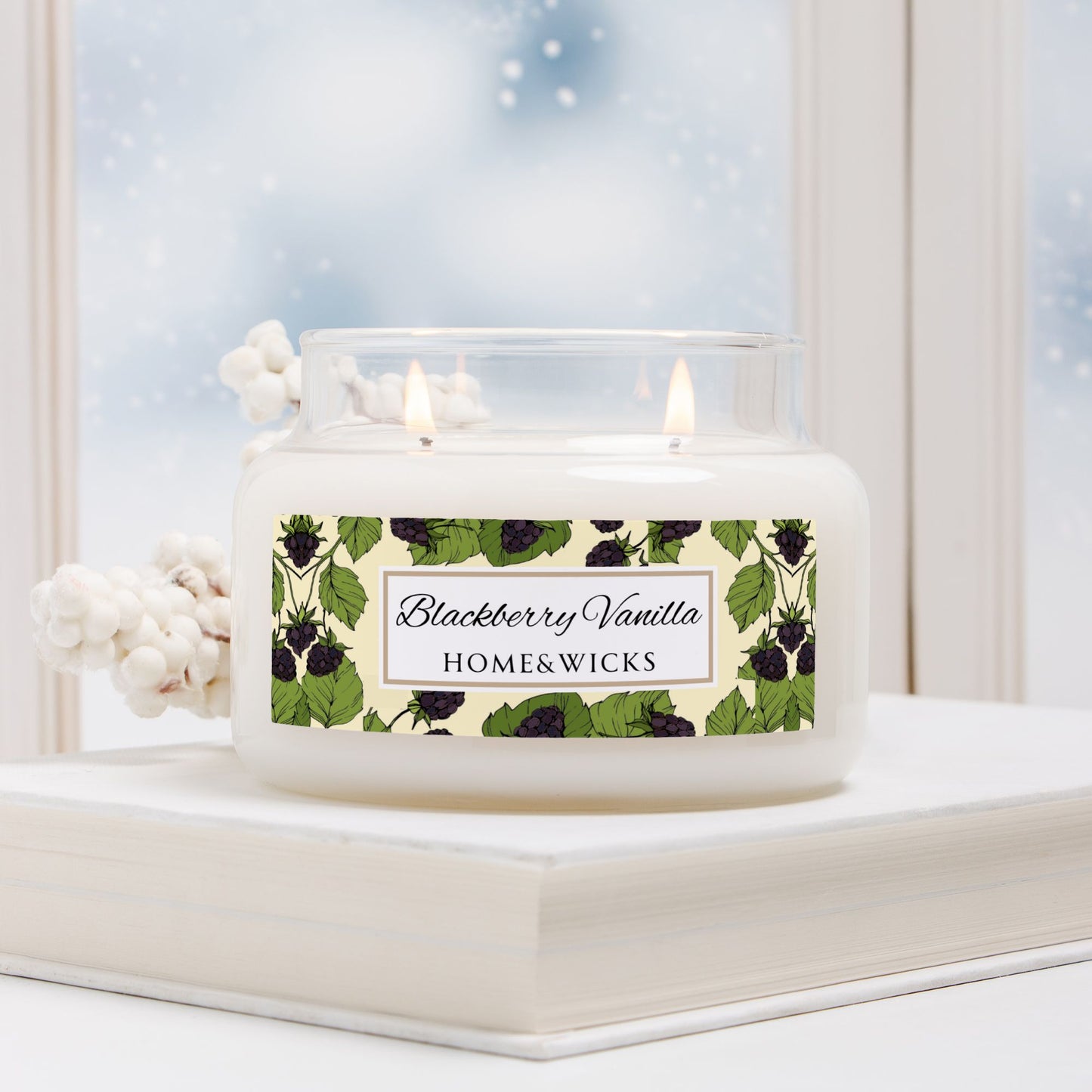 Candle with 'Blackberry Vanilla' label on a windowsill with a snowy background