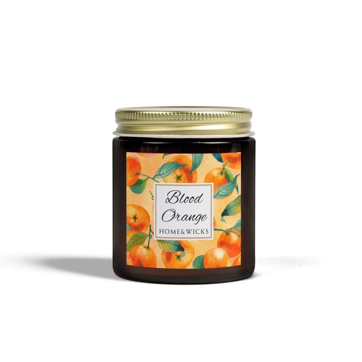Blood Orange candle in an amber glass jar with gold lid with 'Blood Orange' label featuring oranges illustration on a white background by Home & Wicks
