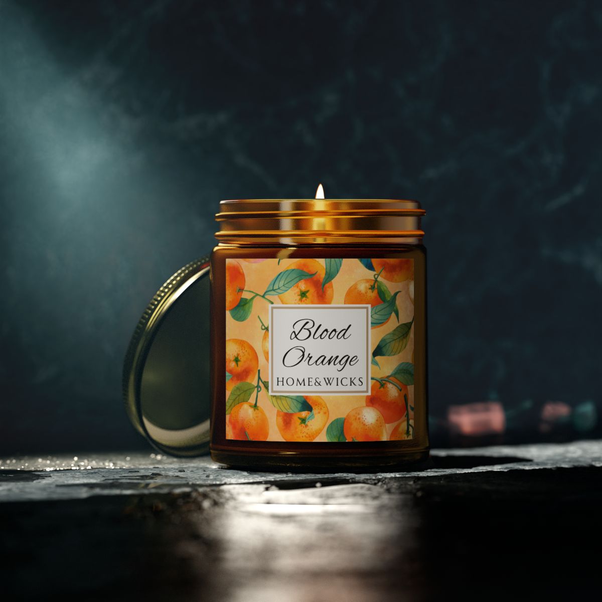 Blood Orange cotton wicked apricot coconut wax candle in an amber jar with gold lid and with 'Blood Orange' label and orange design on a white background by Home & Wicks with a decorative label featuring oranges on a dark background