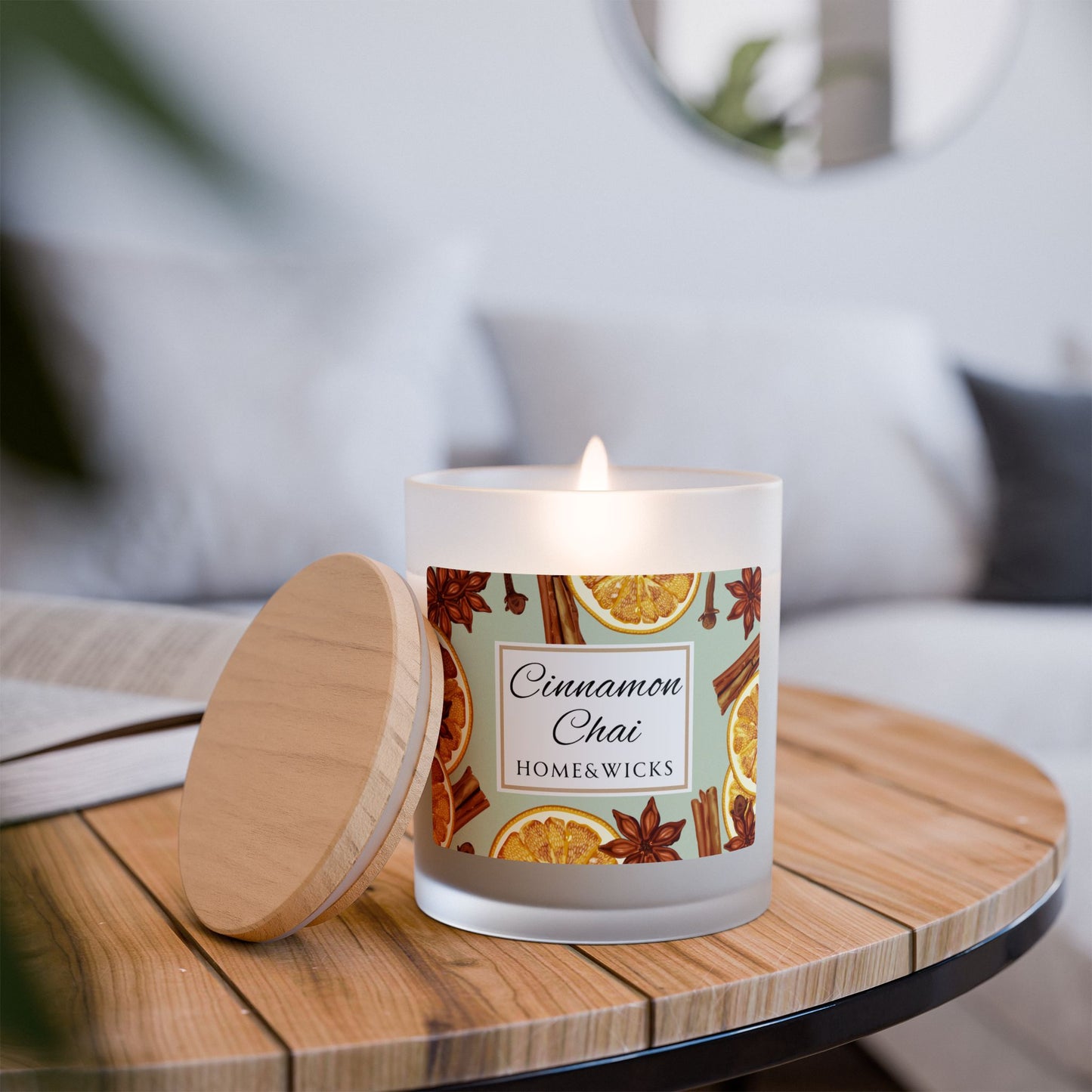 Candle labeled 'Cinnamon Chai' by Home & Wicks on a wooden table with a blurred background