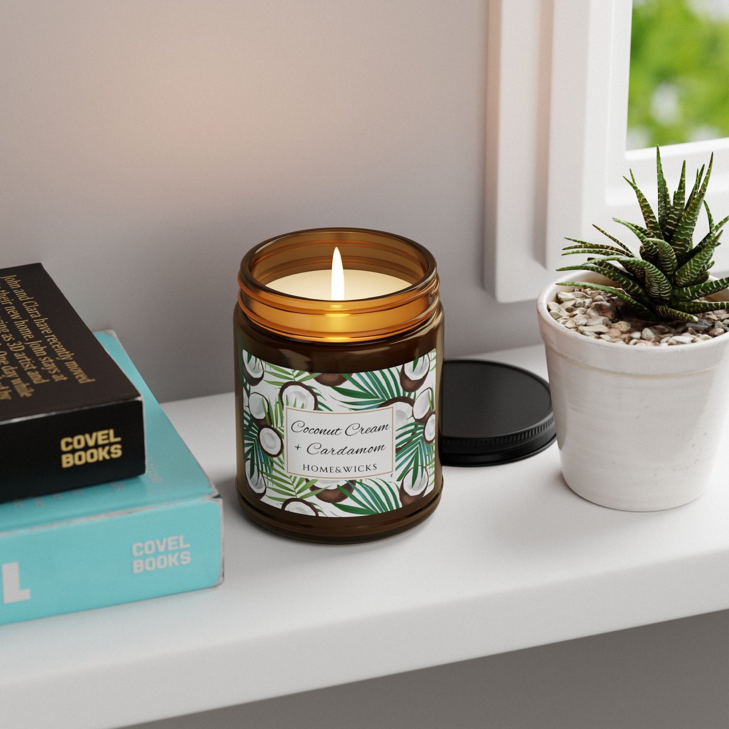 Candle in an amber jar with a label, books, and a plant on a shelf.