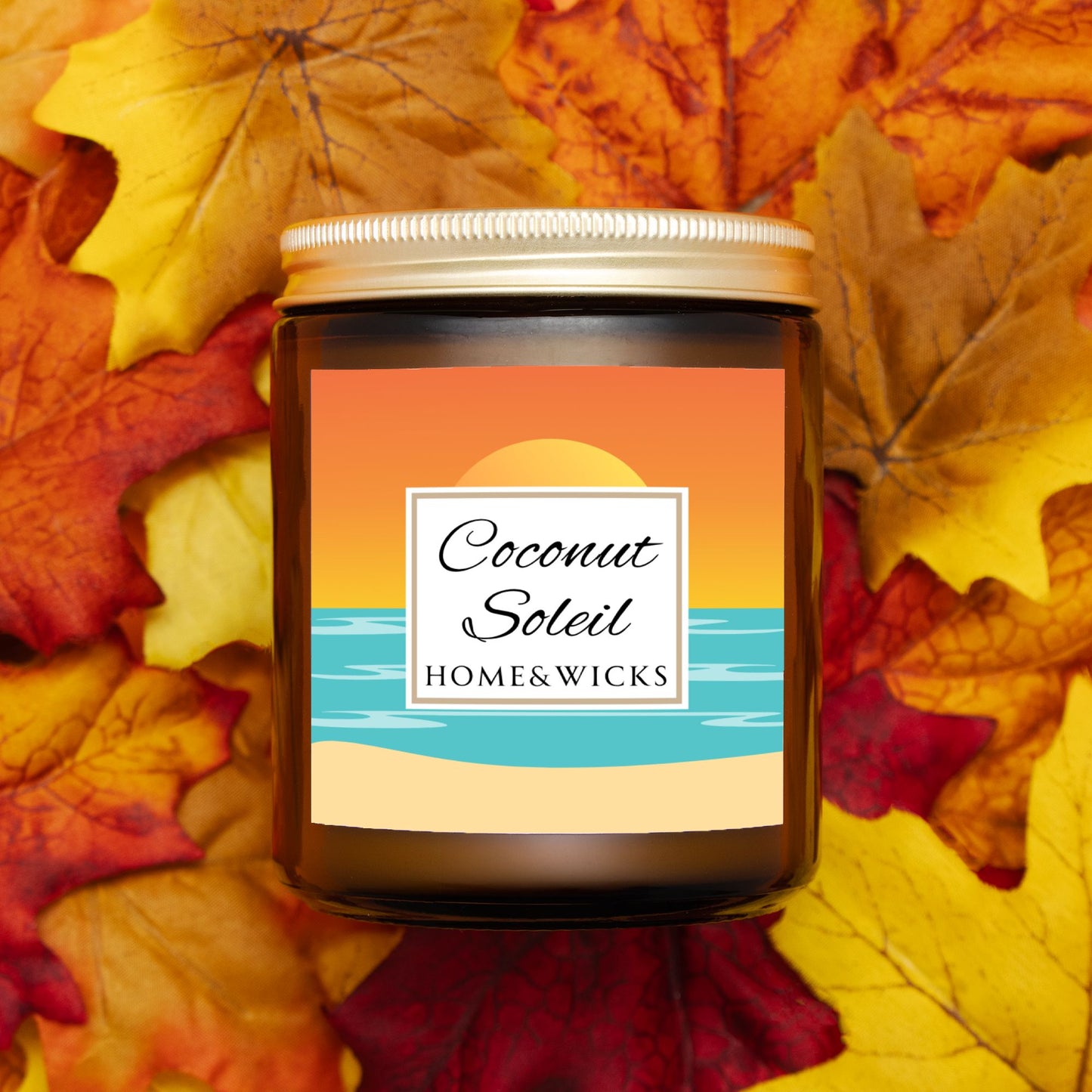 Coconut Soleil coconut apricot wax candle in an amber jar with gold lid with a colorful ocean sunset graphic label featuring 'Coconut Soleil' by Home & Wicks on a white background on a bed of autumn leaves.