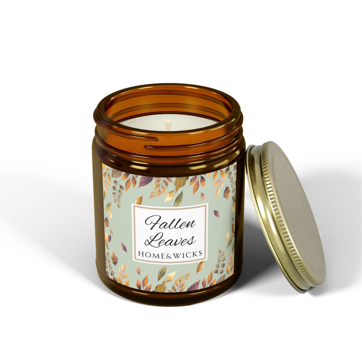 Cotton wick amber glass candle jar with brown, gold and green 'Fallen Leaves' label on a white background by Home & Wicks