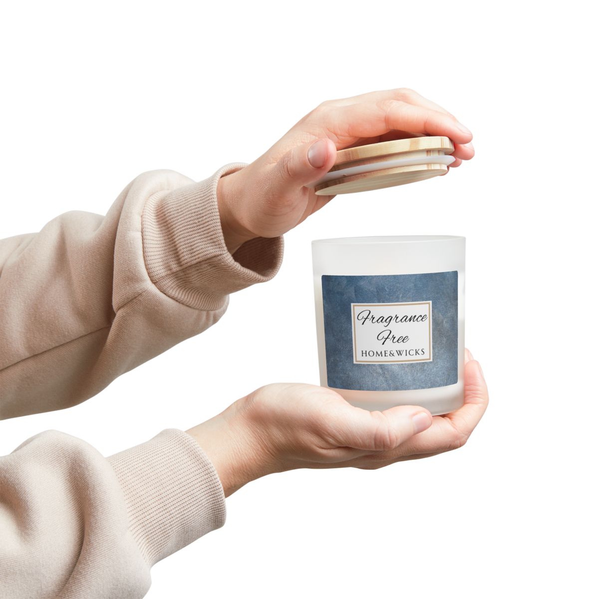 Person holding a candle labeled 'Fragrance Free' by Home & Wicks on a white background