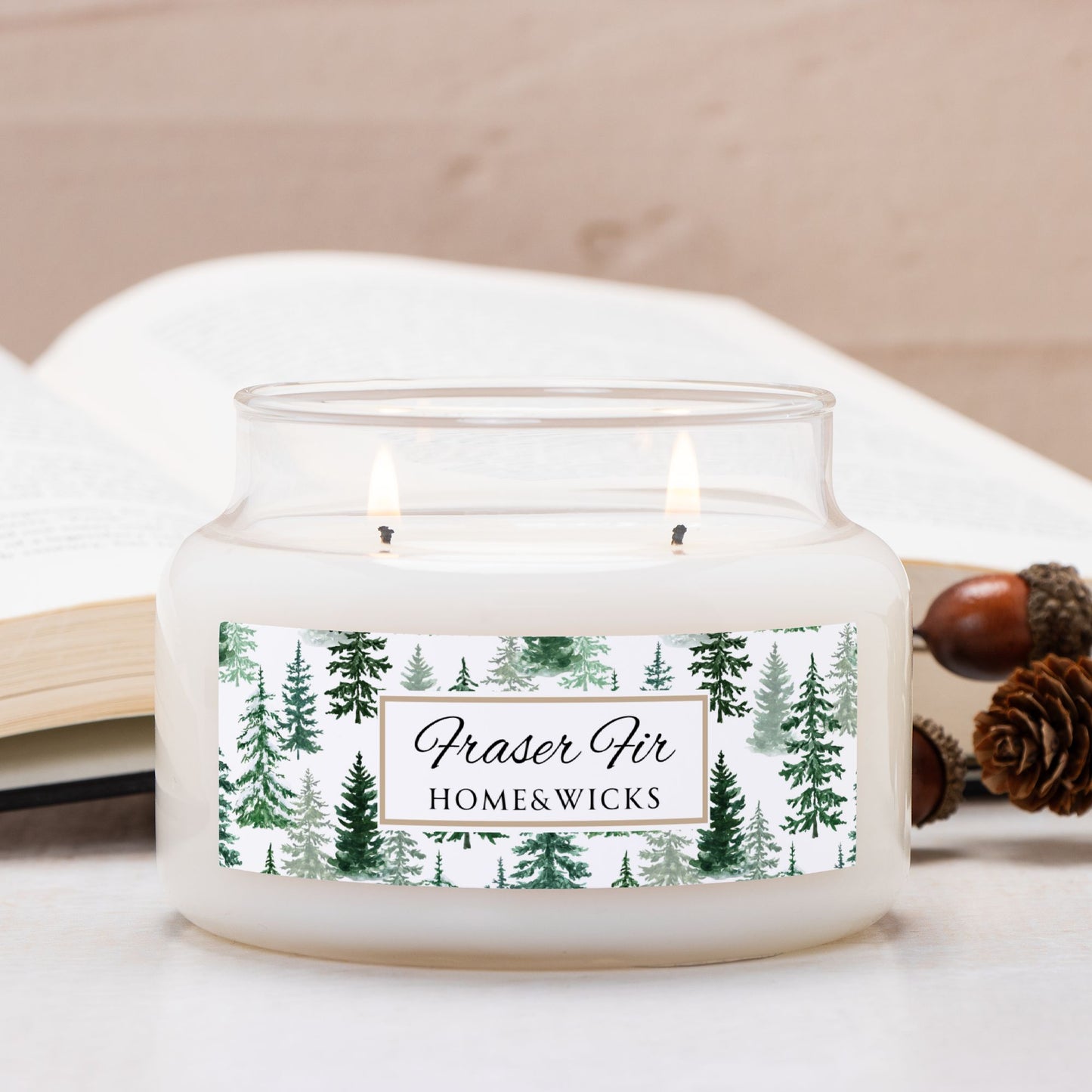 Candle in a glass jar with a 'Fraser Fir' label on a white surface with acorns.
