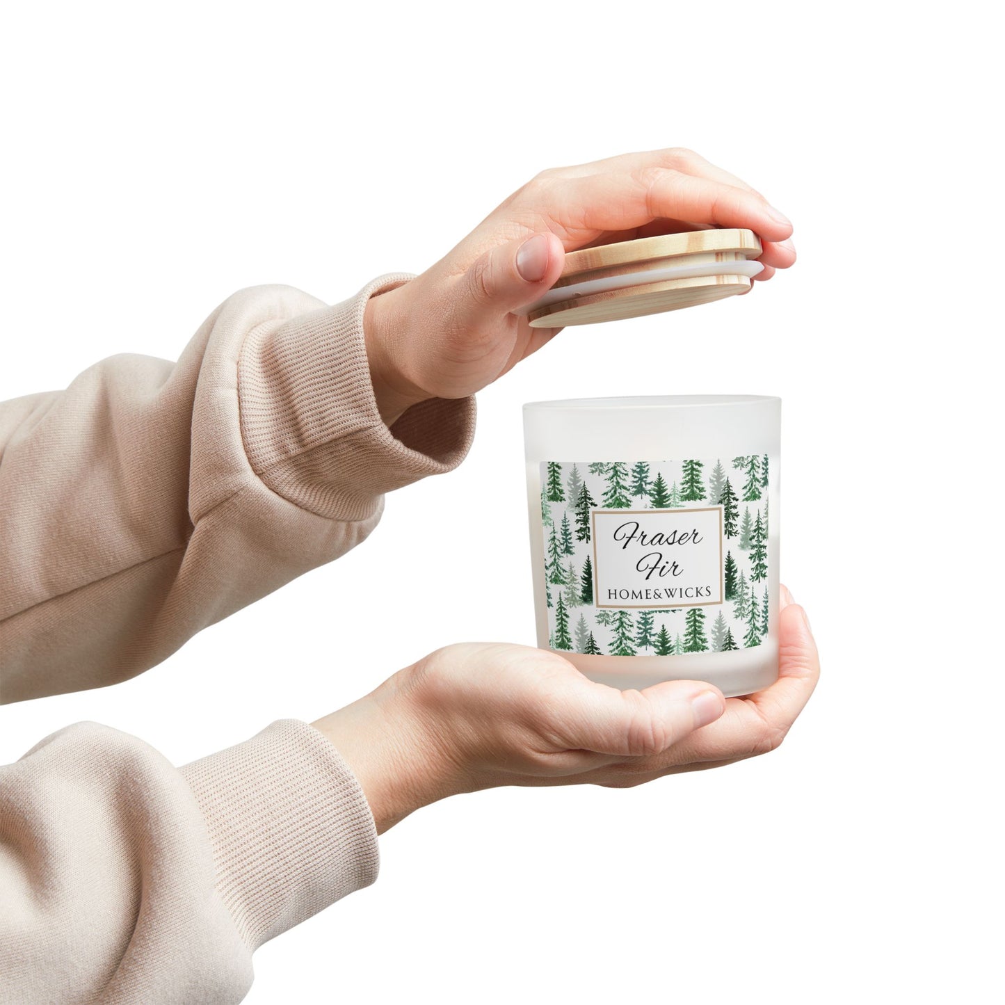 Person holding a candle with a forest design Fraser Fir label against a white background
