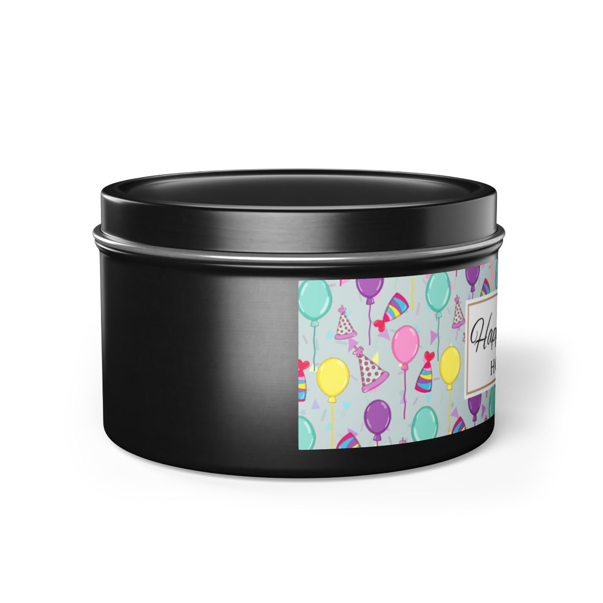 Side view of black black candle tin with 'Happy Birthday' label with colorful balloon, birthday hats and confetti design on a white background