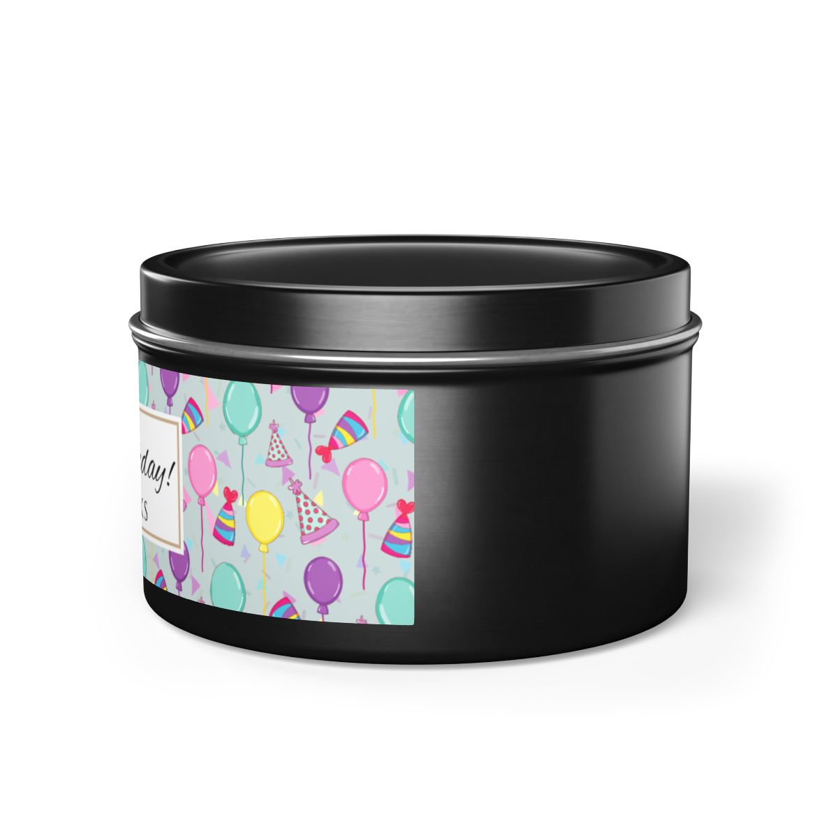 Side view of black black candle tin with 'Happy Birthday' label with colorful balloon, birthday hats and confetti design on a white background