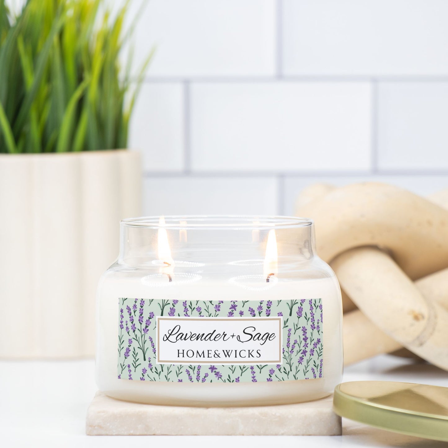 Candle with a 'Lavender & Sage' label on a marble surface with lavender flowers in the background.