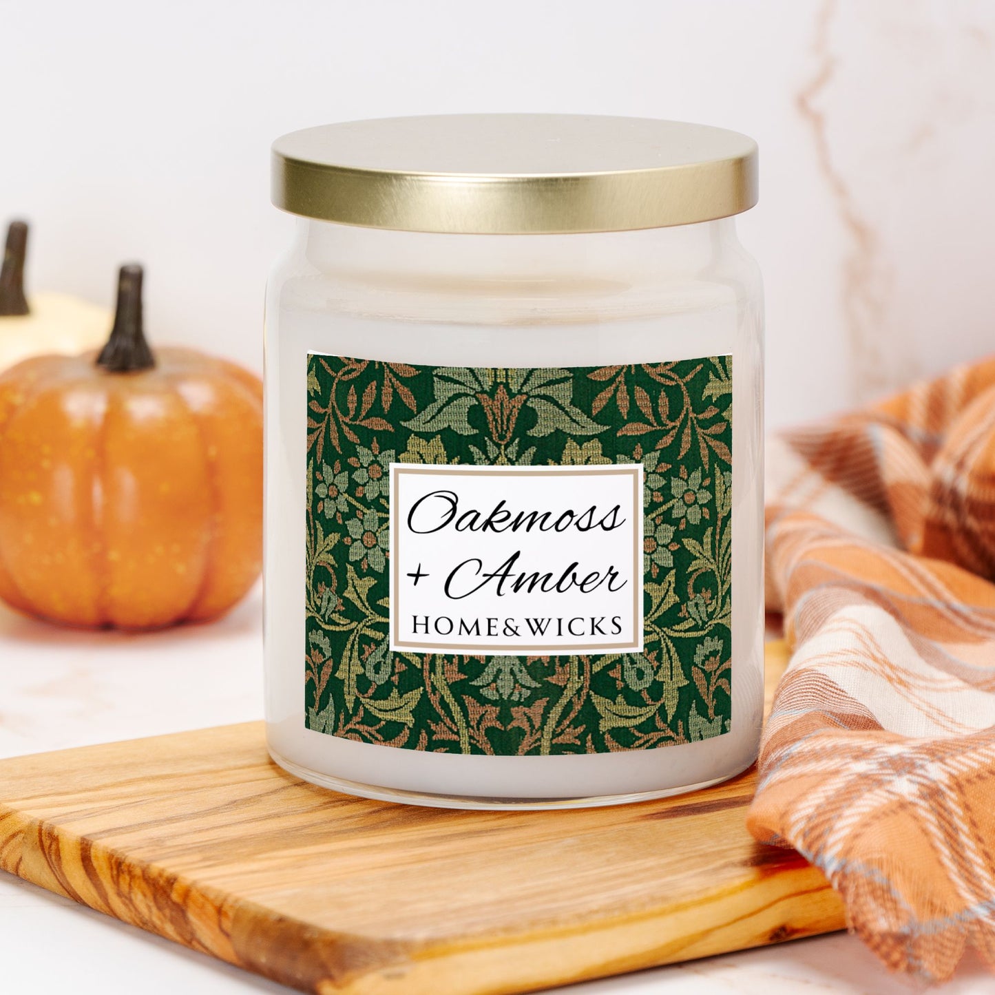 Candle jar with a decorative Flower Garden label on a wooden board with pumpkins and a blanket in the background