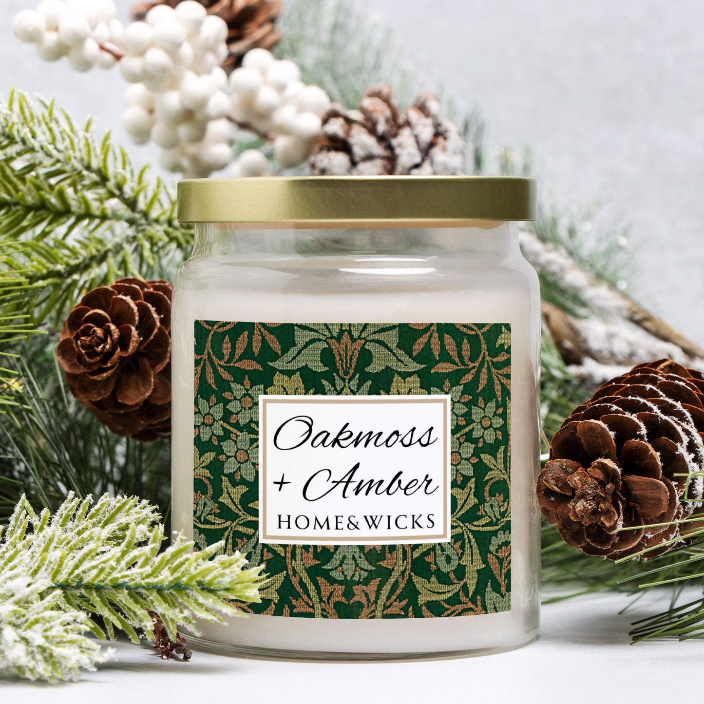 Candle jar labeled 'Oakmoss + Amber' from Home & Wicks surrounded by festive elements.