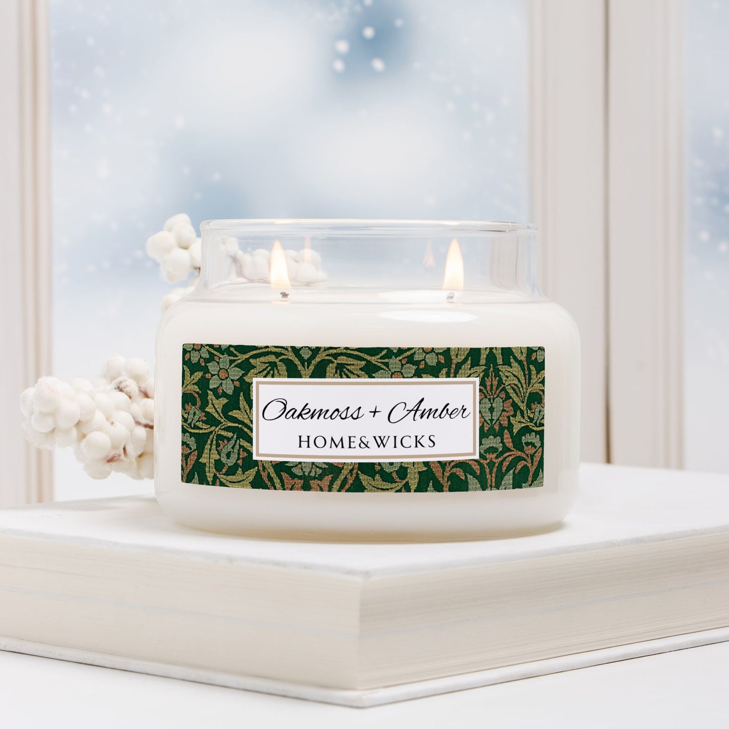 Candle with a decorative label on a windowsill with a snowy background