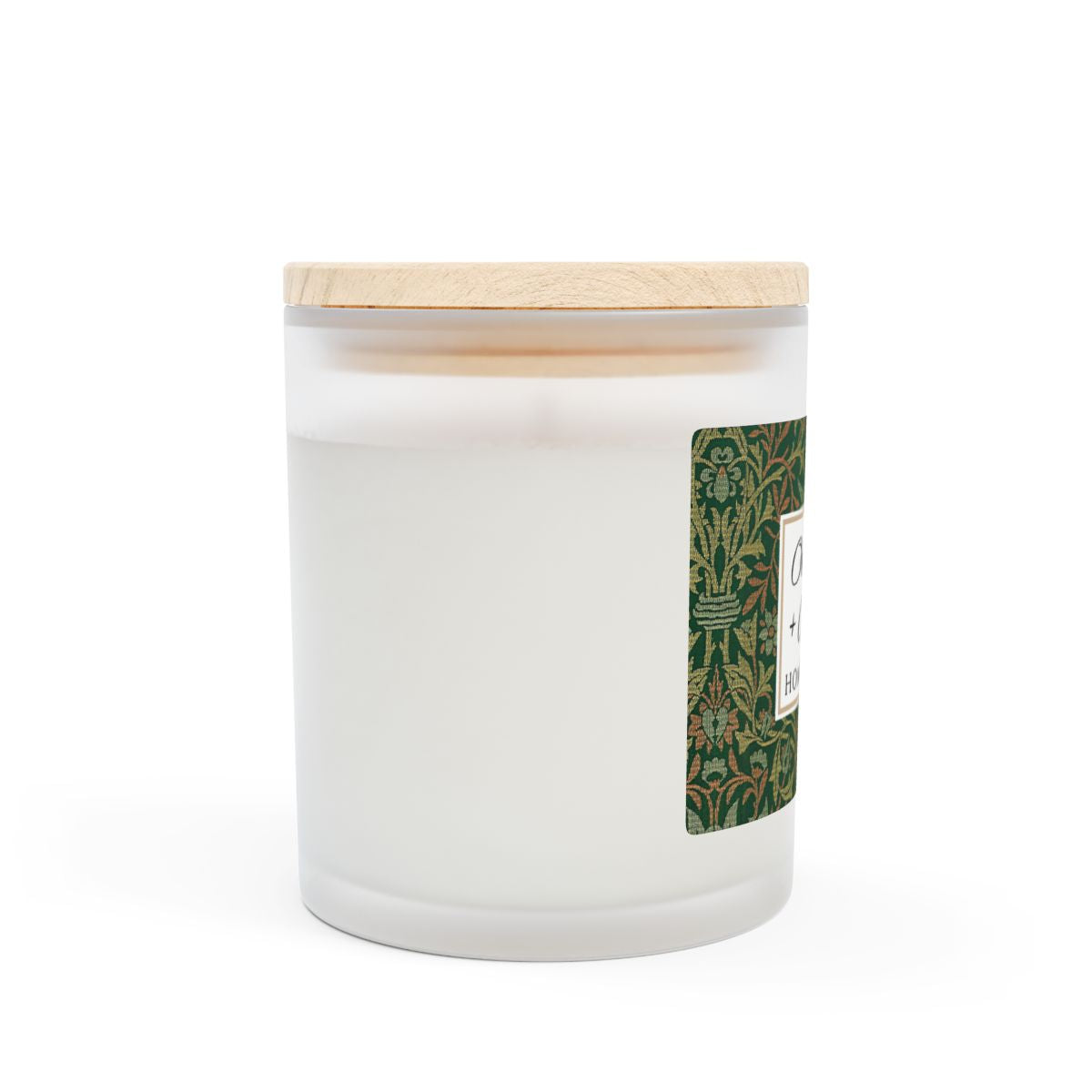 Side view of wood wick Oakmoss & Amber candle in a frosted glass jar with a green decorative label featuring the illustration by William Morris "Flower Garden" on a white background by Home & Wicks