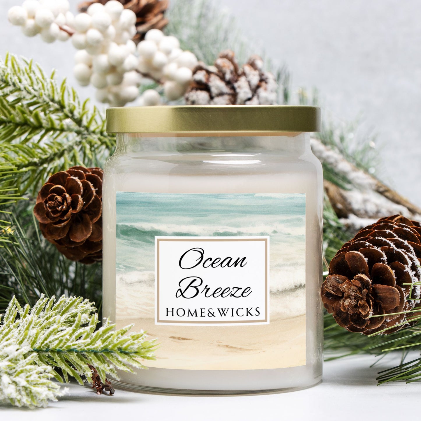 Candle labeled 'Ocean Breeze' from Home & Wicks surrounded by decorative elements on a light background