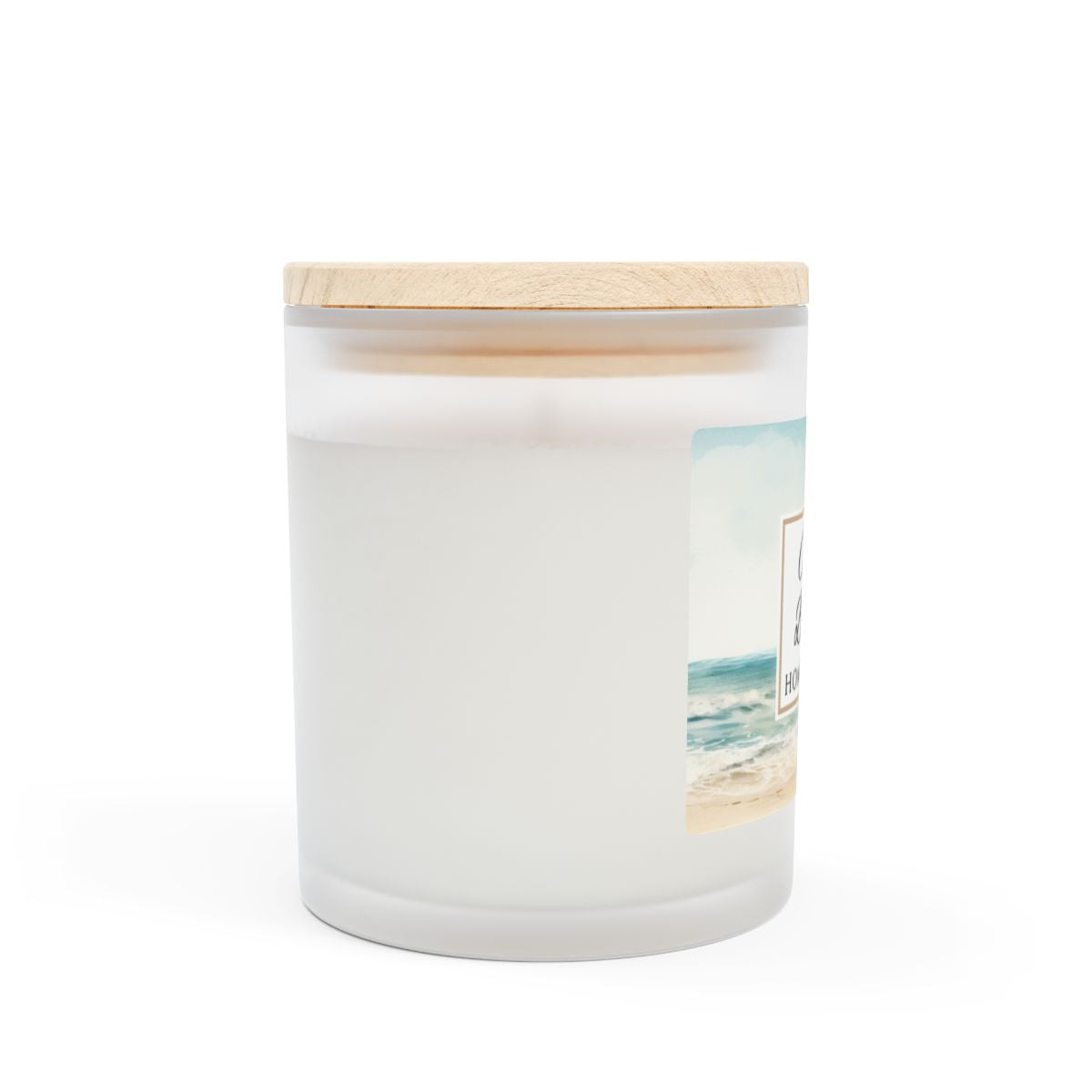 Side view of Ocean Breeze wood wick candle with a wooden lid and beach scene design on a white background