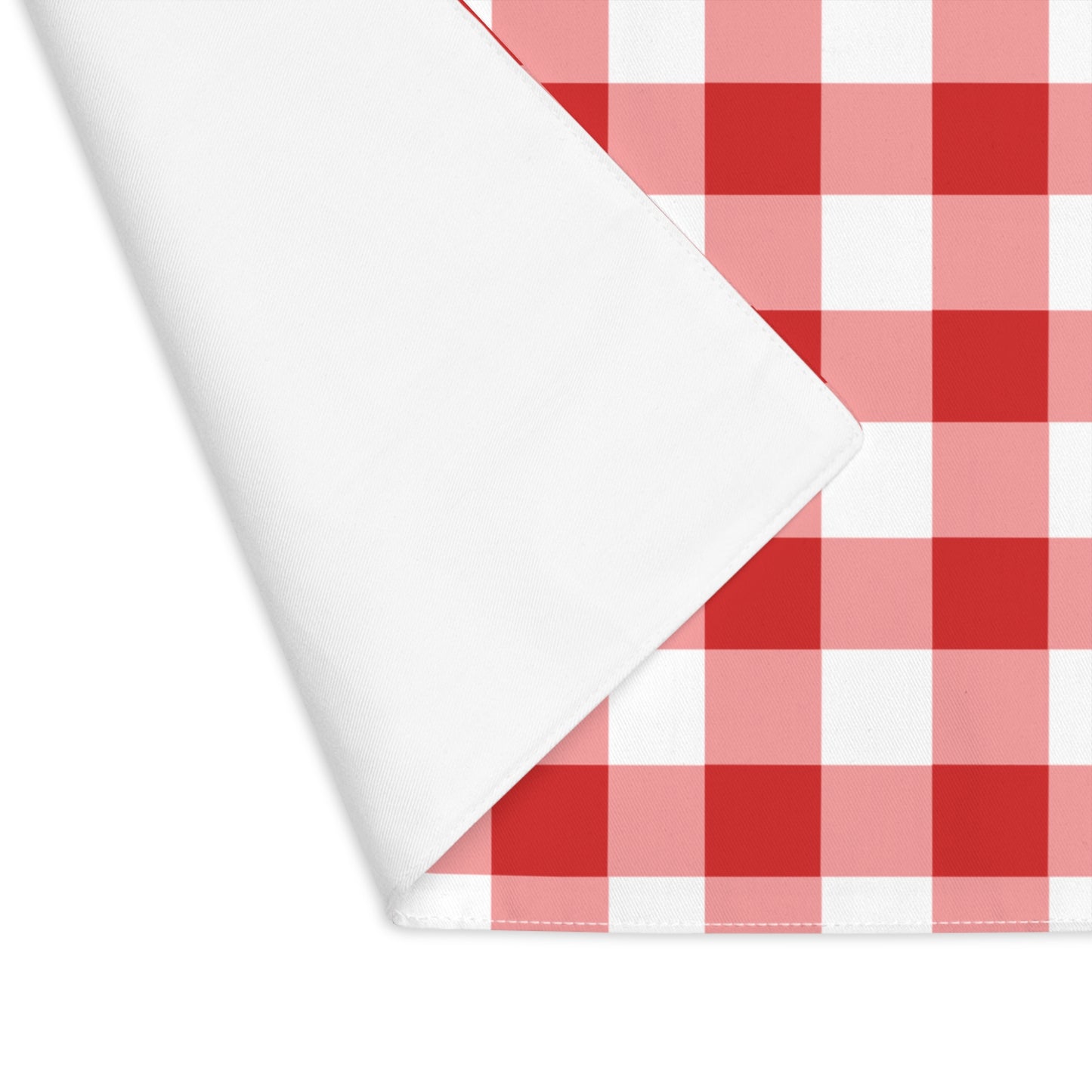 Red gingham placemat with red and white checkered pattern, with placemat corner folded over to reveal white backside, on a white background
