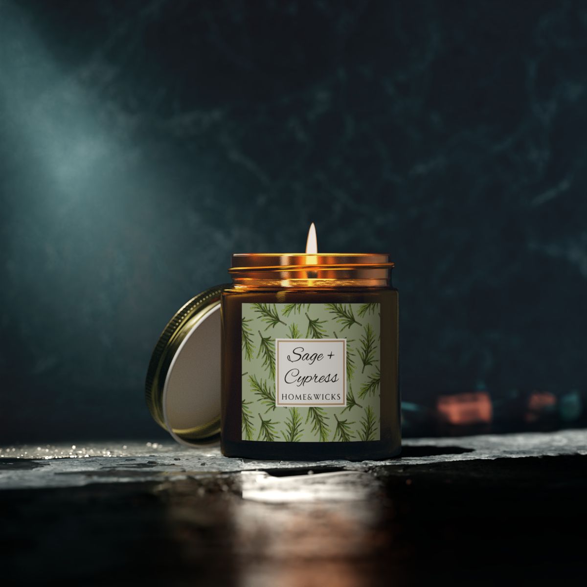 Sage & Cypress candle in a 4 oz. amber glass jar with a gold lid and 'Sage + Cypress' label on a white background by Home & Wicks on a dark background