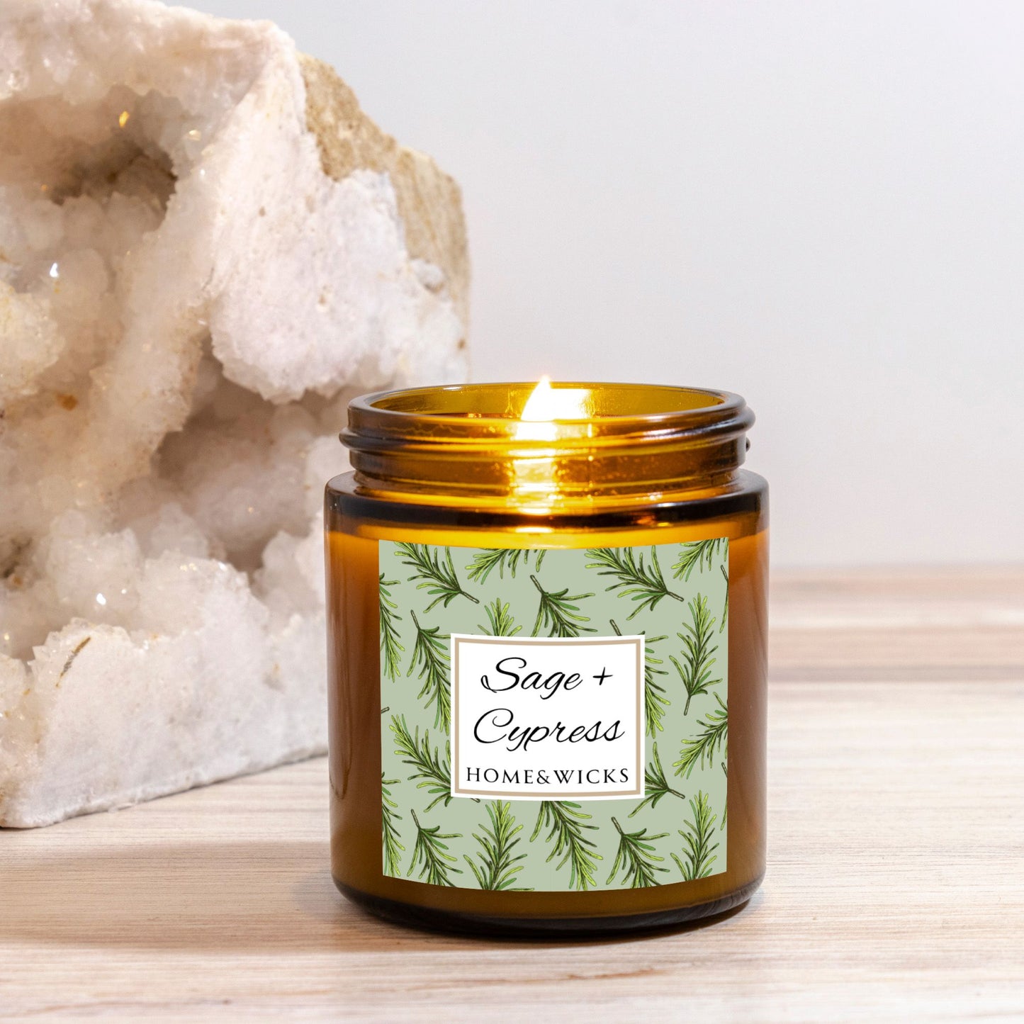 Sage & Cypress candle in a 4 oz. amber glass jar with a gold lid and 'Sage + Cypress' label on a white background by Home & Wicks placed against a white background.