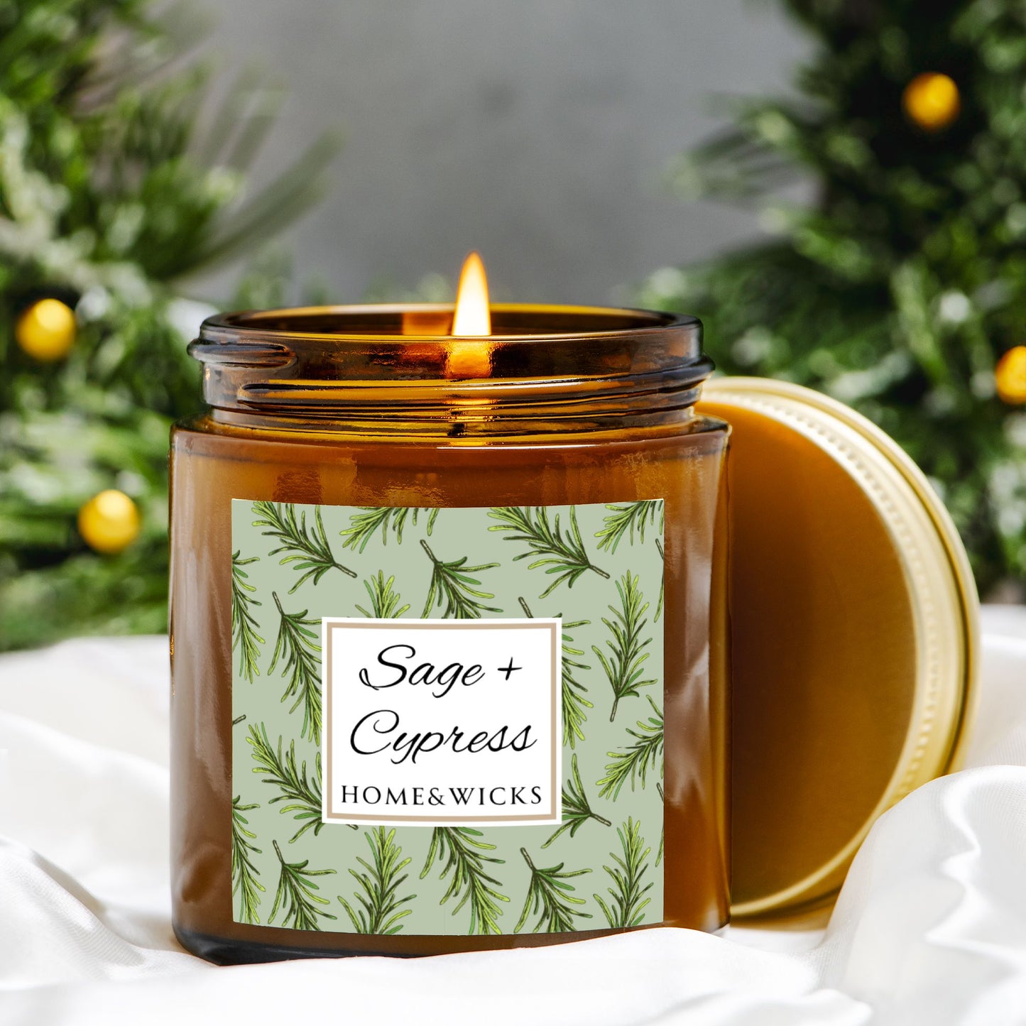 Sage & Cypress candle in a 4 oz. amber glass jar with a gold lid and 'Sage + Cypress' label on a white background by Home & Wicks with a green label featuring plant imagery.