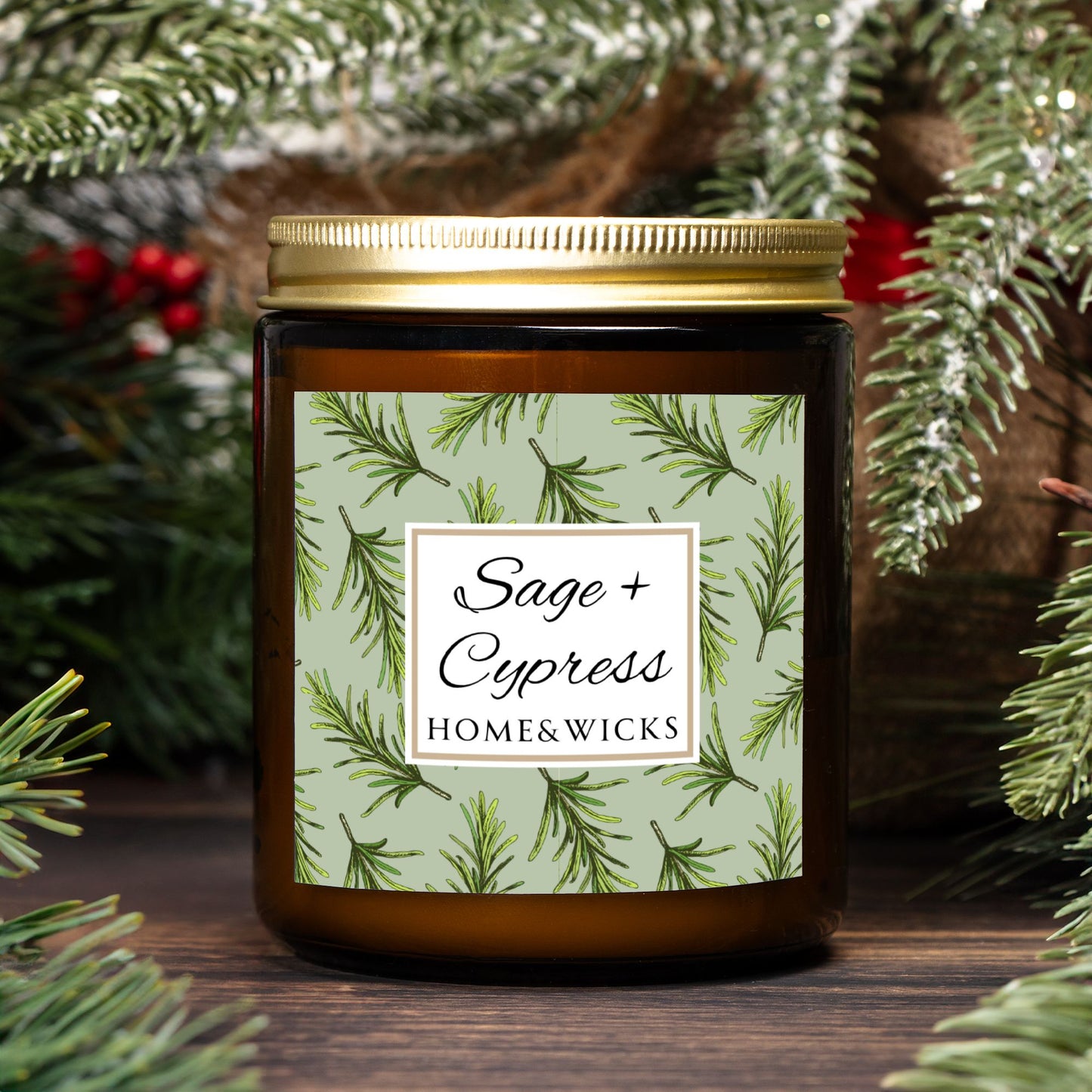 Sage & Cypress candle in an amber jar with gold lid with 'Sage + Cypress' label on a light green background with cypress needle leaves with green leaf pattern, surrounded by pine branches.