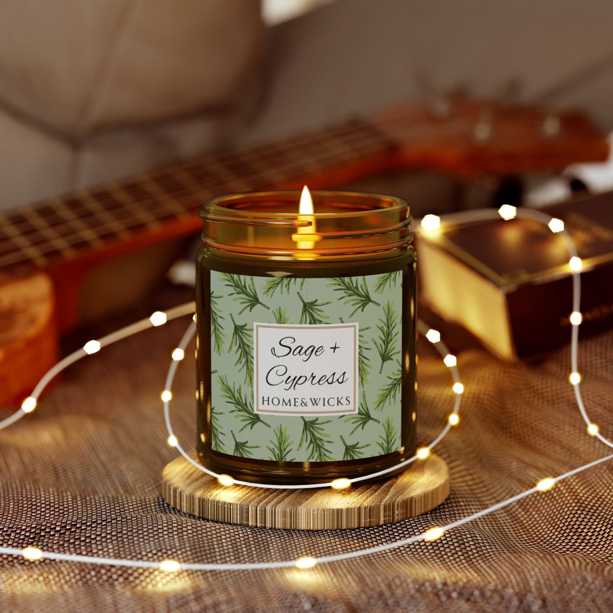 Sage & Cypress candle in an amber jar with gold lid with 'Sage + Cypress' label on a light green background with cypress needle leaves