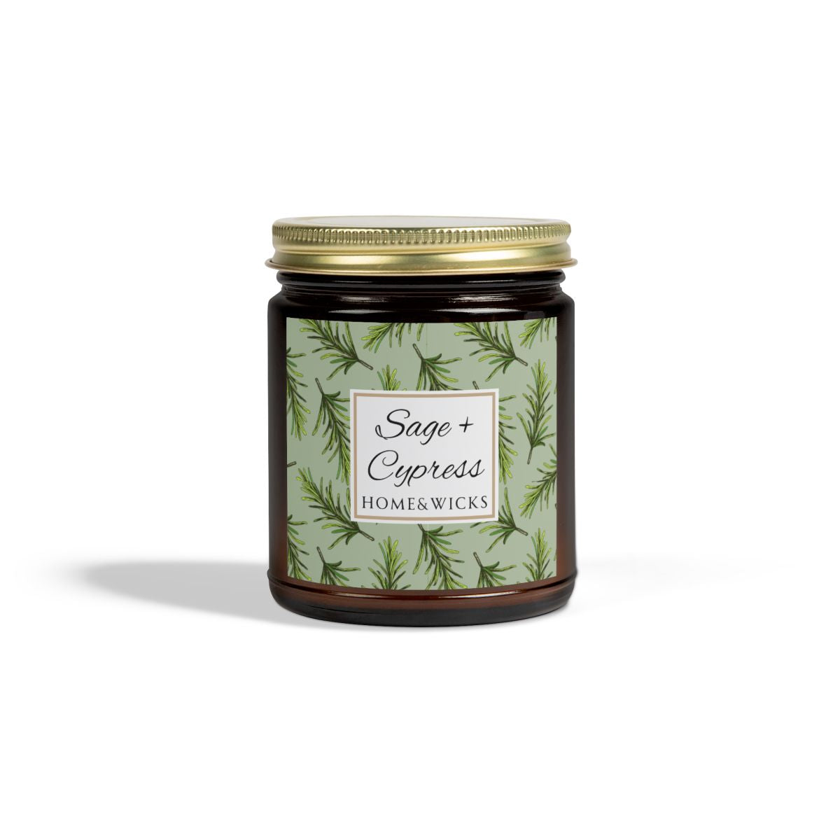 Sage & Cypress candle in an amber jar with gold lid with 'Sage + Cypress' label on a light green background with cypress needle leaves