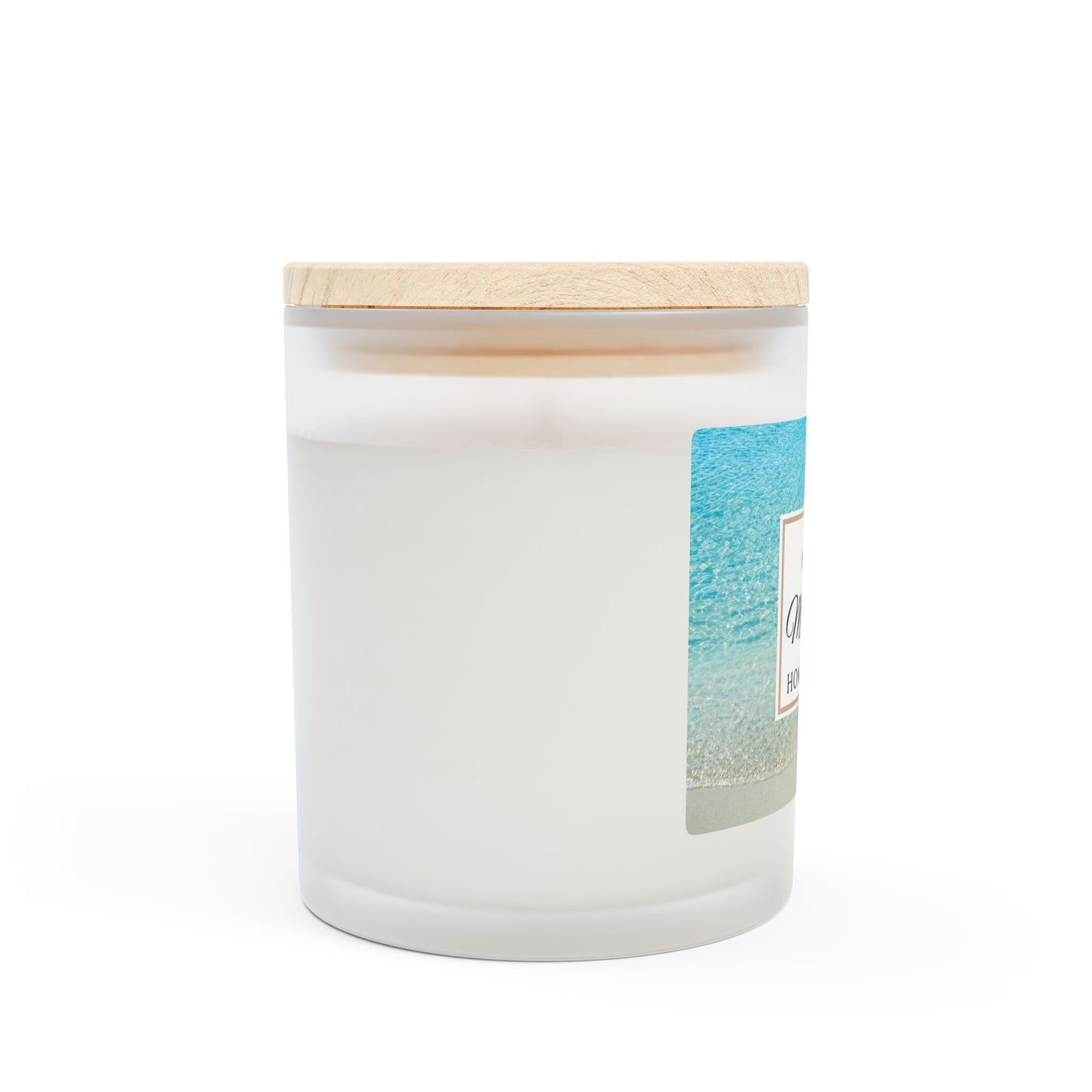 White candle with a wooden lid and beach-themed label on a white background
