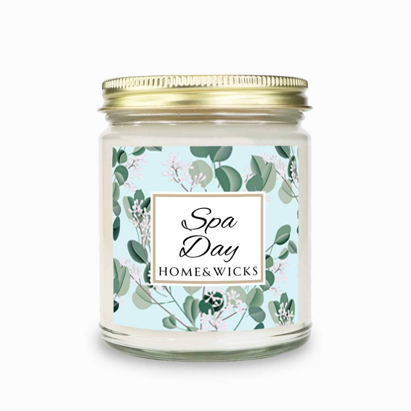 Spa Day candle clear jar with gold lid with a decorative eucalyptus label on a white background by Home & Wicks