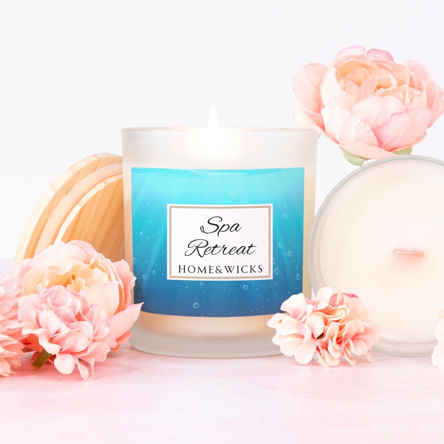 Candle labeled 'Spa Retreat' by HOME & WICKS with pink wood wick and pink flowers on a white background
