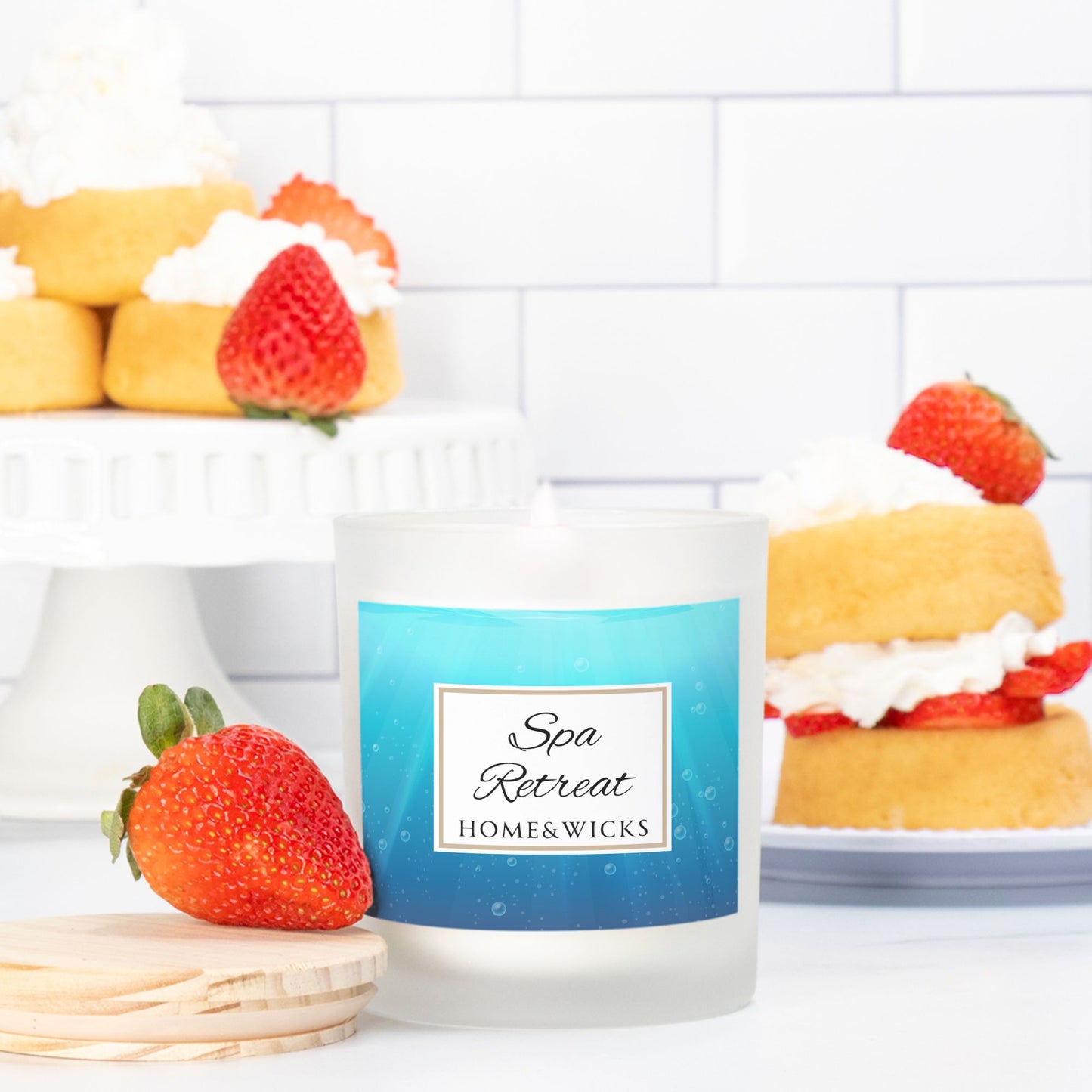 Candle labeled 'Spa Retreat' by Home & Wicks with strawberries and cakes in the background.