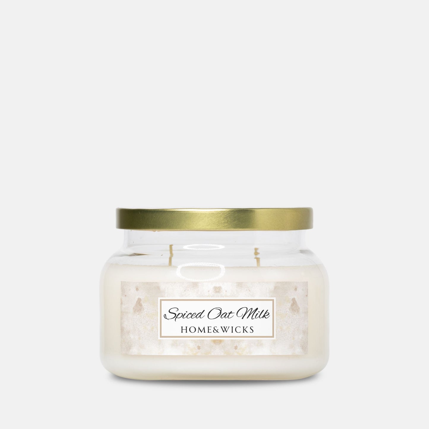 Candle jar labeled 'Spiced Oat Milk' by Home & Wicks with gold lid on a white background