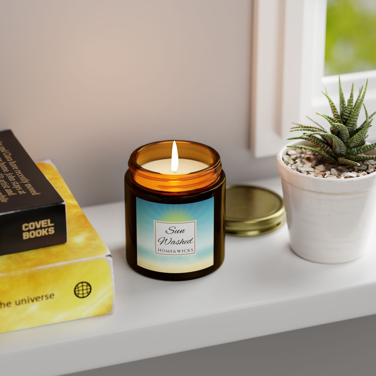 Sun Washed candle in a 4 oz. jar labeled 'Sun Washed' with sun graphic by Home & Wicks on a white background with a label, books, and a potted plant on a surface.