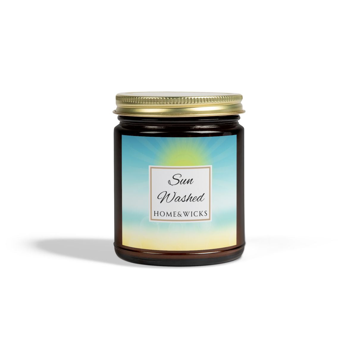Candle in a 9 oz. amber jar with gold lid with 'Sun Washed' label on with sun graphic gradient background by Home & Wicks on a white background