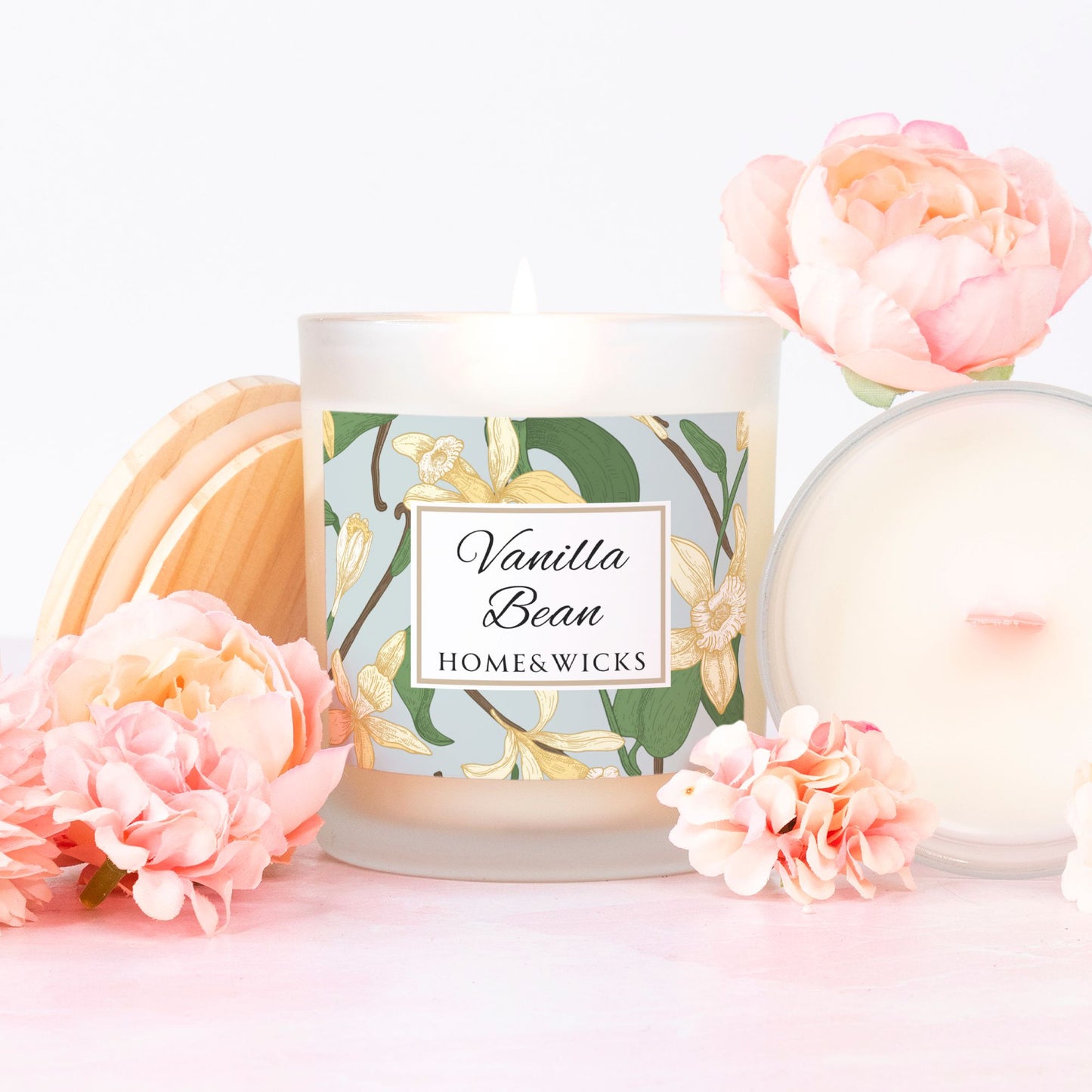 Vanilla Bean candle from Home & Wicks with vanilla bean floral design and pink flowers around it.