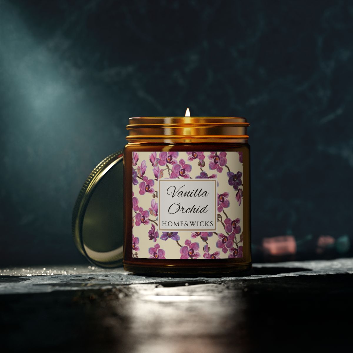 Vanilla Orchid candle in an amber jar with gold lid with a pink and purple orchid design label by Home & Wicks on a dark background