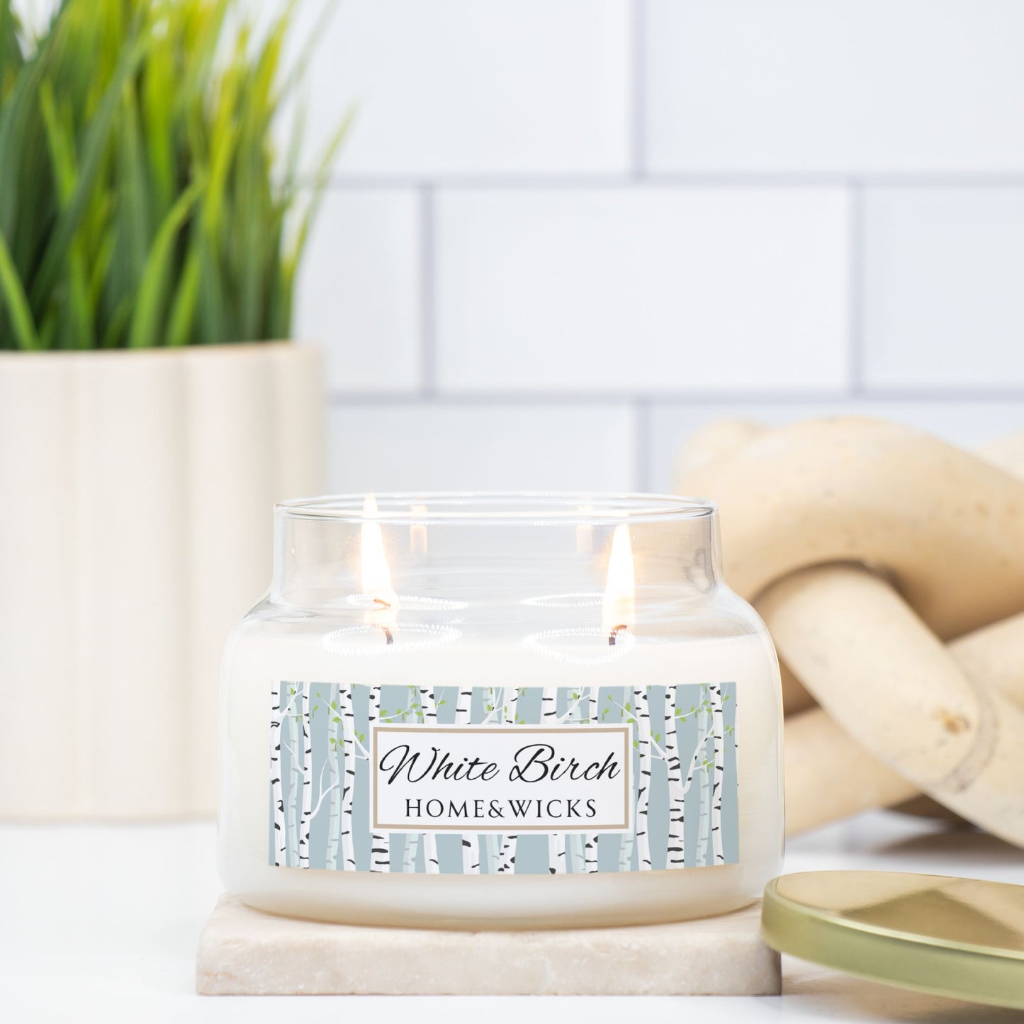 Candle labeled 'White Birch' from Home & Wicks on a surface with a blurred background