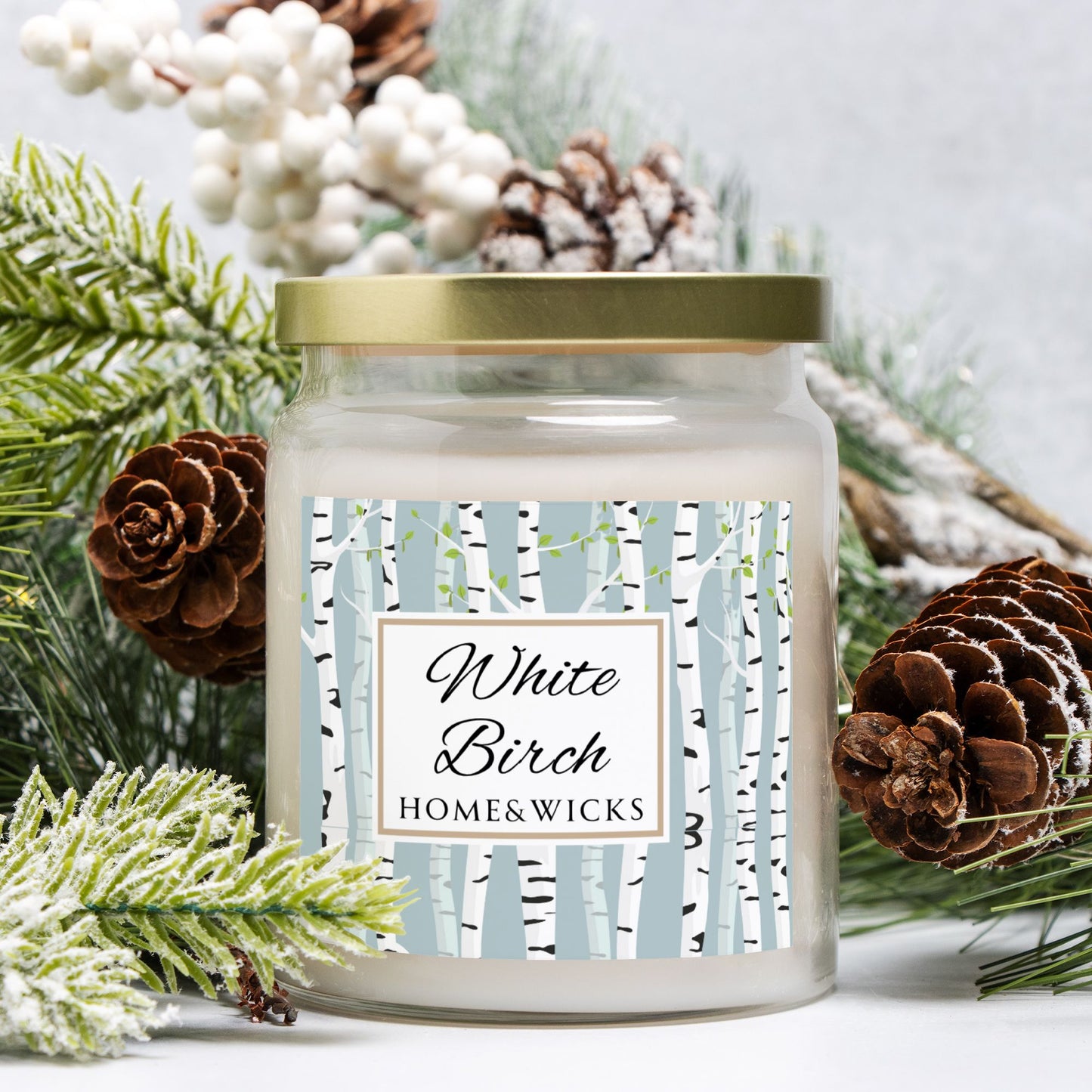 Candle jar labeled 'White Birch' by Home & Wicks surrounded by decorative elements on a light background