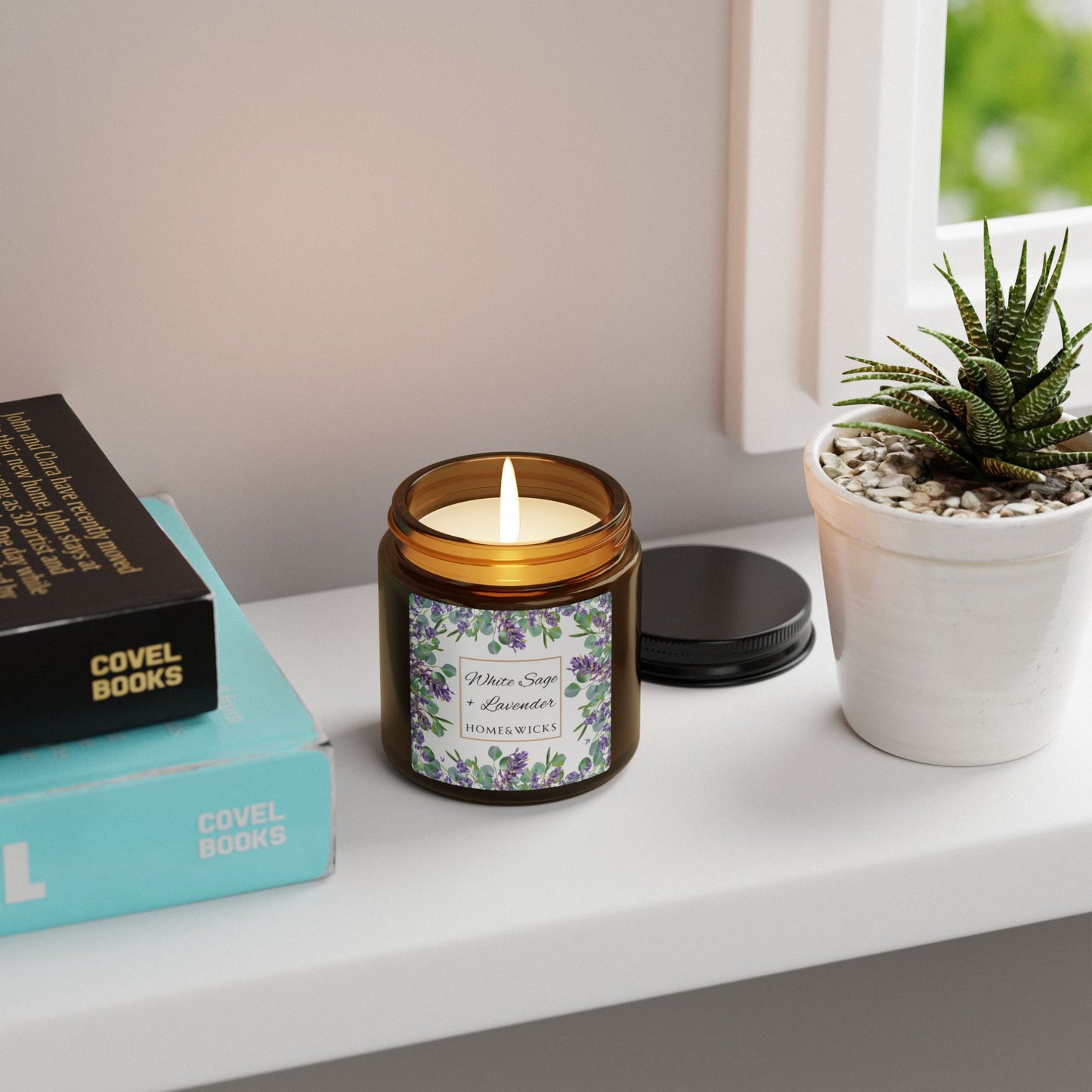 Candle in a amber glass jar with a label on a shelf next to books and a plant