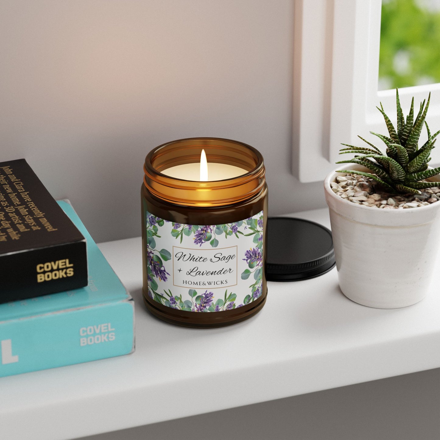 Candle in an amber jar with a floral label on a shelf with books and a plant