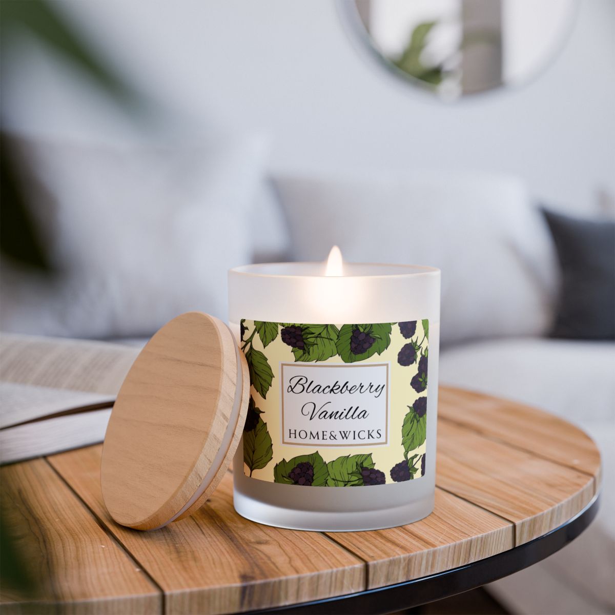 Lit wood wick Blackberry Vanilla candle with a label featuring blackberries and leaves image on a white background by Home & Wicks on a wood table