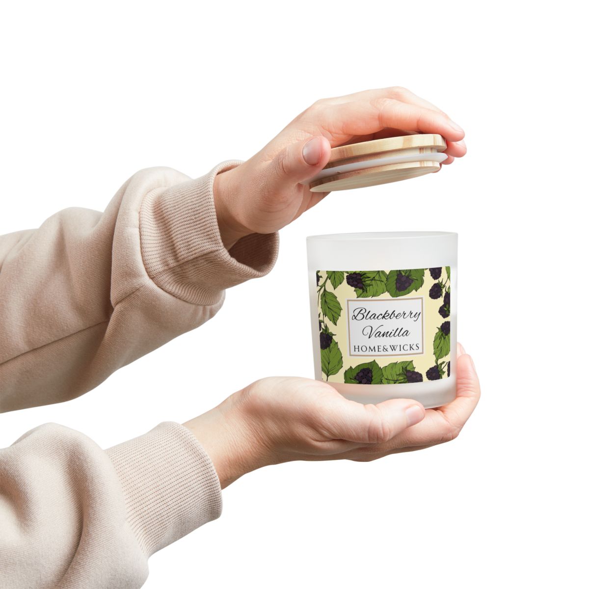 Person holding a candle labeled 'Blackberry Vanilla' by Home Wicks on a white background