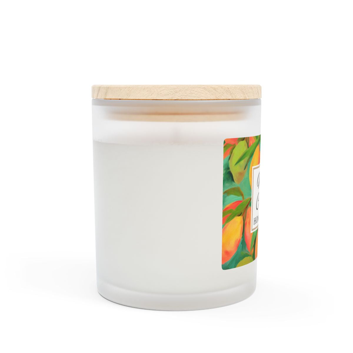 Side view of wood wick candle with a green and orange mango coconut label on a frosted glass candle jar on a white background by Home & Wicks
