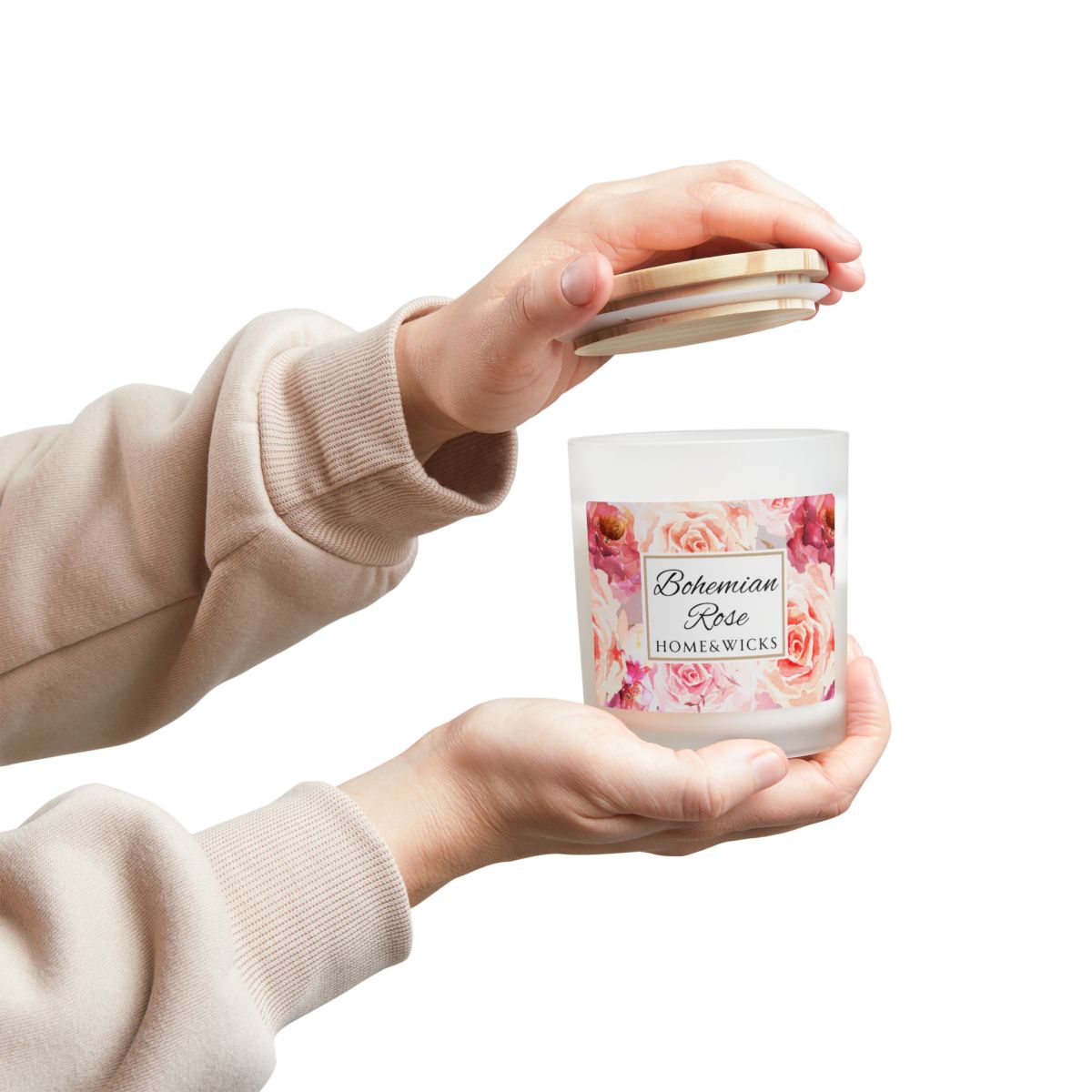 Person holding a candle labeled 'Bohemian Rose' by Home & Wicks on a white background