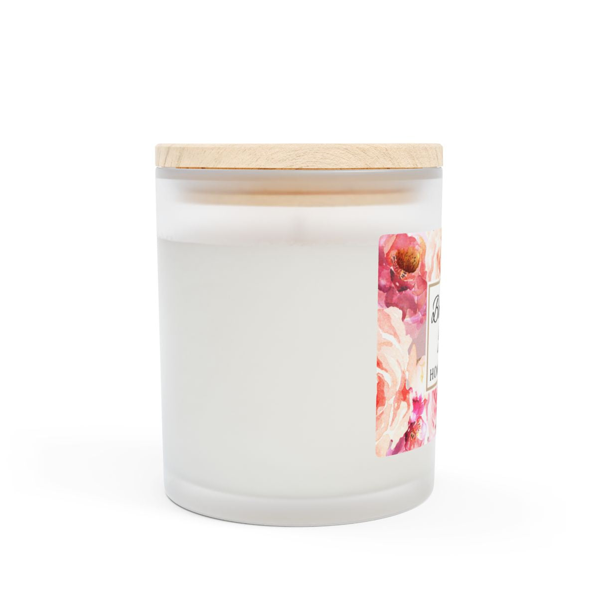 Side view of white frosted candle jar with a wooden lid and floral label on a white background