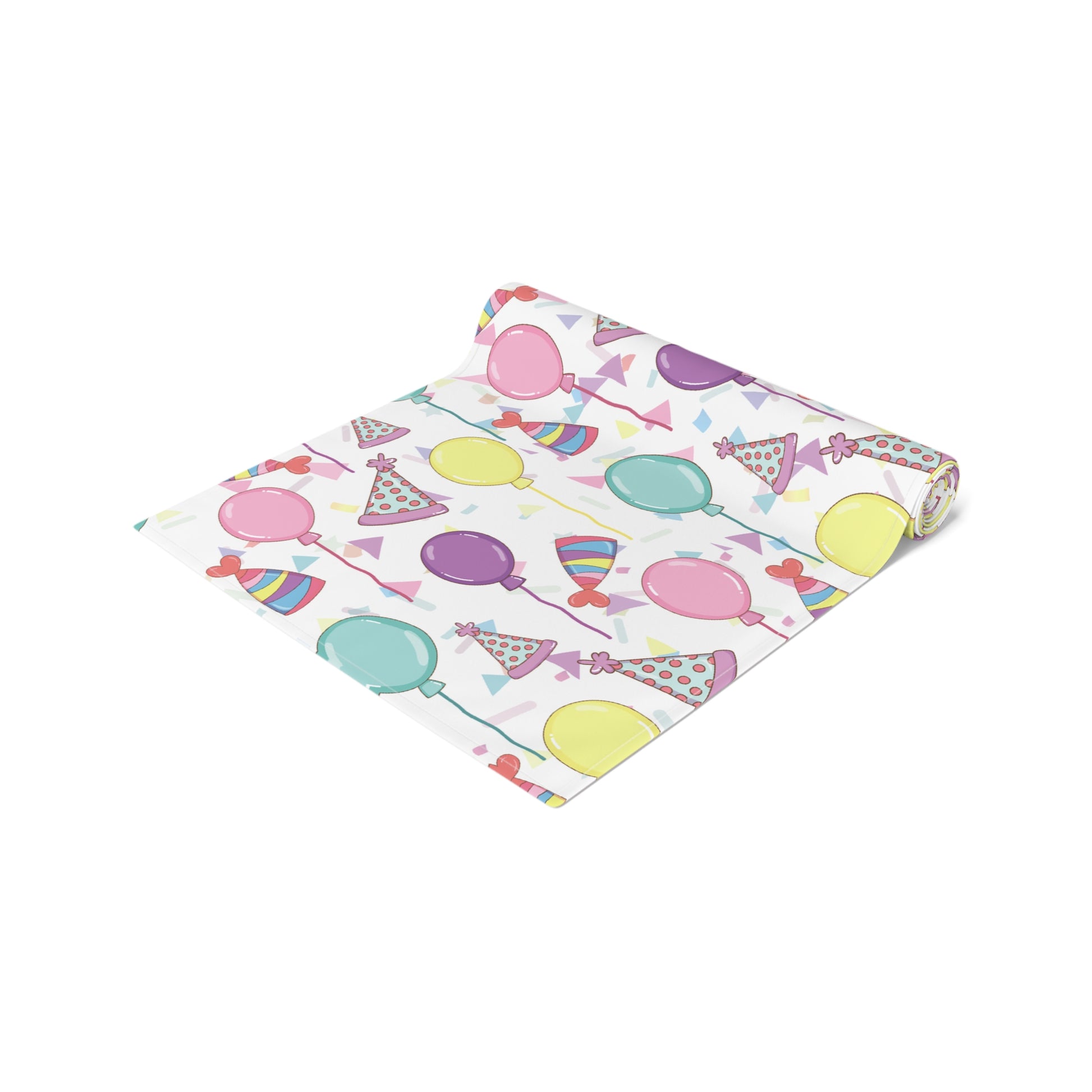 Table runner with birthday hats, confetti and purple, yellow, blue and pink balloons design rolled up on a white background 