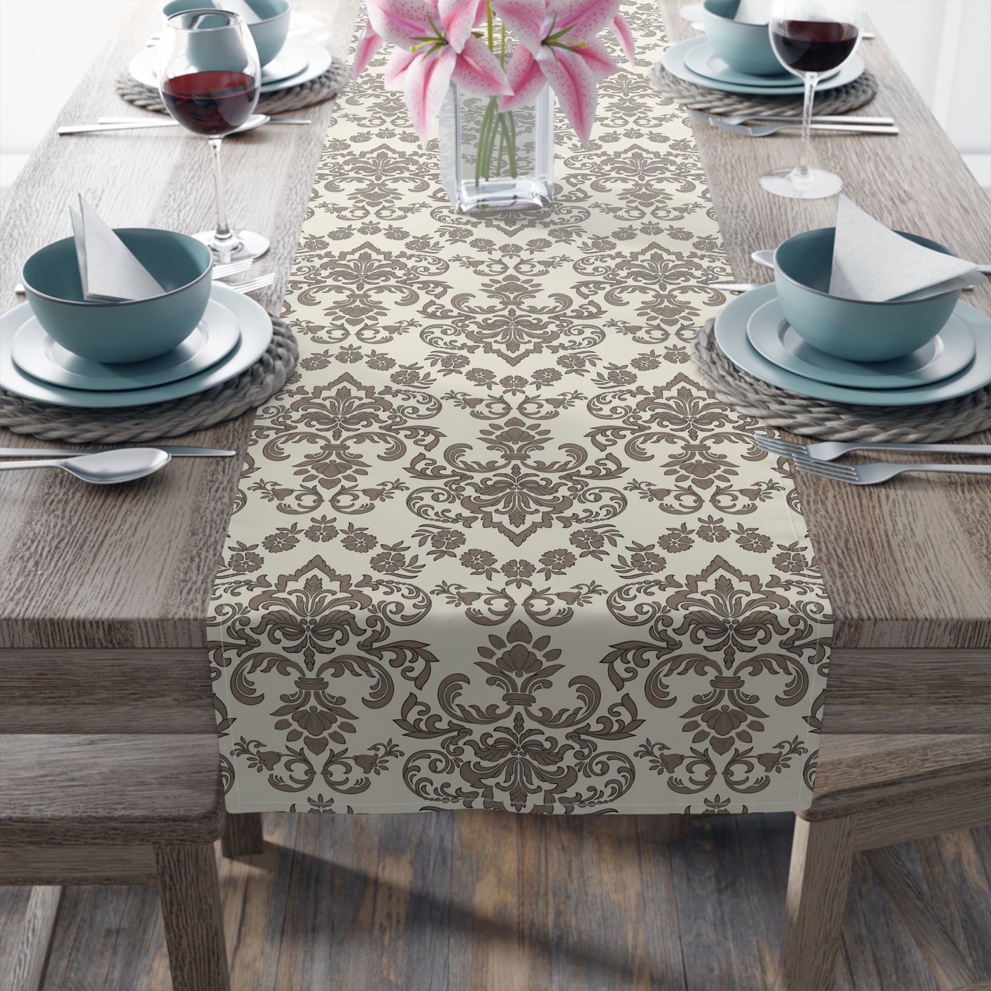 Table setting with a Baroque Moccha table runner with a brown and beige damask pattern on a wooden table.