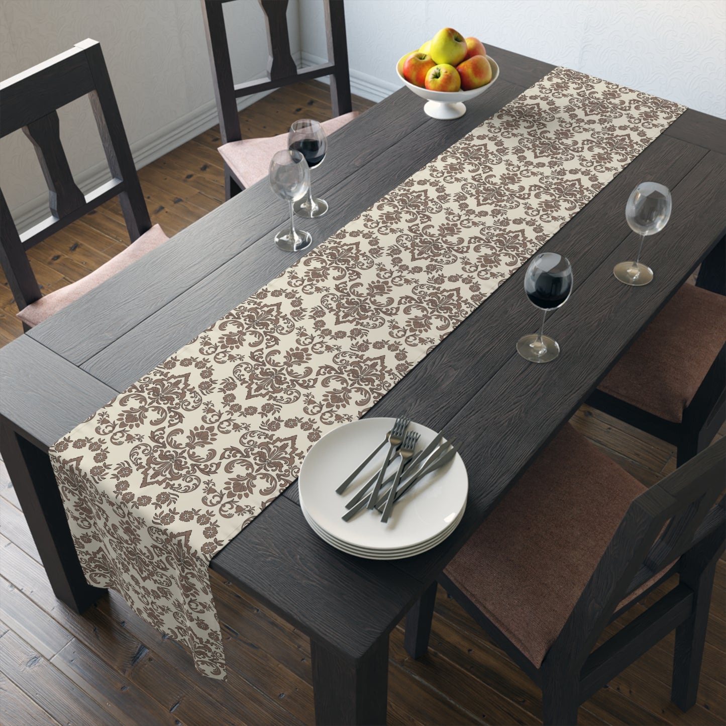 Dining table with a Baroque Mocha table runner that has a brown and beige damask pattern on table runner, plates, and glasses in a room.