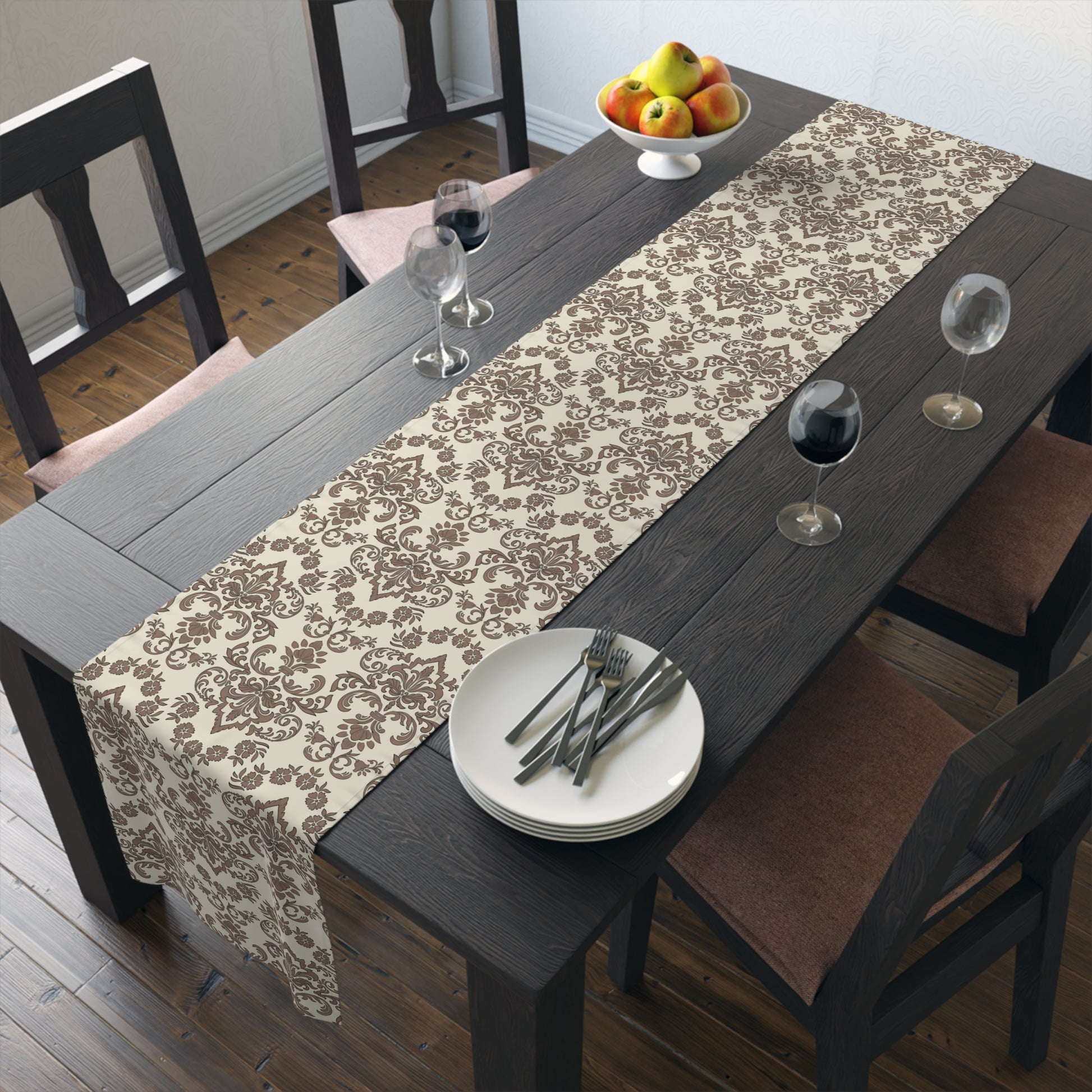 Dining table with a Baroque Mocha table runner that has a brown and beige damask pattern on table runner, plates, and glasses in a room.