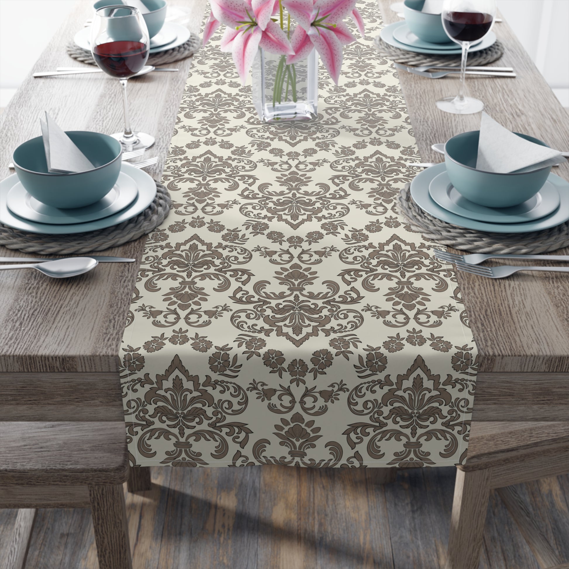 Decorative Baroque Mocha table runner with a brown and beige damask floral pattern on a wooden table set for dinner.